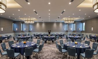 a large , well - lit banquet hall filled with tables and chairs , ready for a meeting or event at Portland Sheraton at Sable Oaks