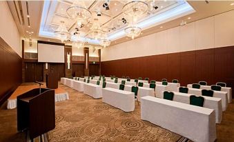 a large conference room with rows of chairs arranged in a semicircle , and a podium in the center at Oarks Canal Park Hotel Toyama