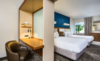 a modern hotel room with a bed , desk , and chair , as well as a window and wall at SpringHill Suites Vero Beach