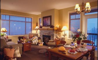 a cozy living room with a fireplace , large windows , and various furniture including sofas , chairs , and a coffee table at Sundance Resort