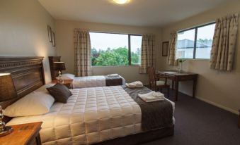 a hotel room with two beds , one on the left and one on the right side of the room at The Lodge