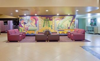 a large , brightly lit lobby with multiple couches and chairs arranged in a seating area at Holiday Home Park Central Port Arthur