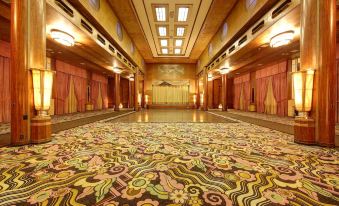 a large , ornate room with a colorful carpet and multiple rows of curtains on the windows at The Queen Mary