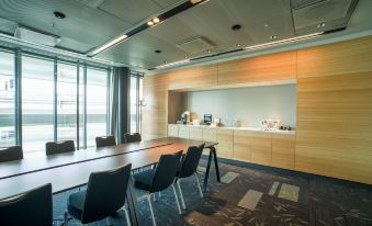 a conference room with a wooden table and chairs , a large window , and a counter at Radisson Blu Waterfront Hotel, Stockholm