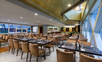 The restaurant features a spacious dining room with tables and chairs arranged in the center, ideal for business luncheons at Ramada Hong Kong Harbour View