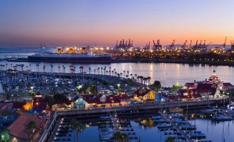 a large marina at dusk , with several boats docked and a city skyline in the background at Hyatt Regency Long Beach