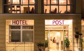 "a hotel entrance with a sign that reads "" hotel post "" prominently displayed on the building" at Hotel Post Alpine Cityflair