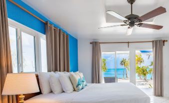 a bedroom with a large bed and a view of the ocean through the window at Pelican Beach Hotel