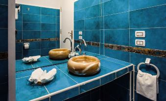 a bathroom with blue tiled walls , a double sink vanity , and a towel hanging on the wall at Desert Moon