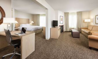 a hotel room with a bed , desk , and laptop is shown in the image at DoubleTree by Hilton Portland - Tigard