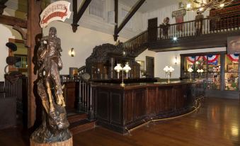 a large , ornate room with a wooden reception desk and a statue of a man on a horse at Disney Hotel Cheyenne