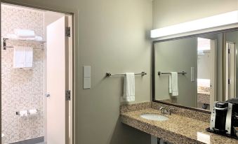 a bathroom with two sinks , one on each side of the room , and a toilet in the background at Holiday Inn Dublin - Pleasanton, an IHG Hotel