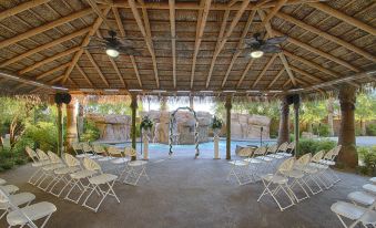 a wedding venue with an outdoor courtyard , where the ceremony is taking place under a thatched roof at Hilton Garden Inn Las Vegas Strip South