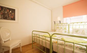 a room with two green metal bunk beds , one on the left and the other on the right side of the room at Garden Apartment