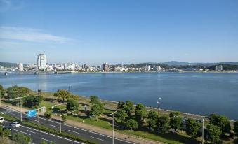 a view of a city with a large body of water in the middle , surrounded by buildings and roads at Hotel Ichibata