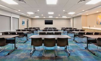 a large conference room with multiple rows of chairs arranged in a semicircle around a long table at Home2 Suites by Hilton Battle Creek