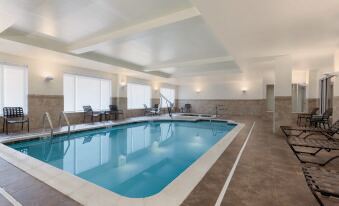 an indoor swimming pool surrounded by lounge chairs and a hot tub , creating a relaxing atmosphere at Hilton Garden Inn Falls Church