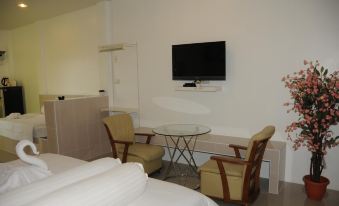 a small hotel room with a bed , two chairs , a tv , and a glass dining table at Saraburi Garden Resort