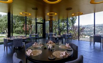a dining room with round tables and chairs arranged for a group of people to enjoy a meal together at Douro Palace Hotel Resort & Spa