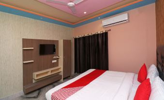 a modern bedroom with pink walls , black curtains , and white beddings , as well as a tv on the wall at Collection O 27949 Hotel Kriti Green