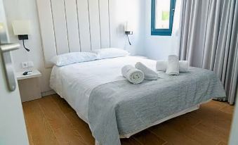 a bed with white sheets and a blue headboard is shown in a room with wooden floors at Hotel Son Vilar