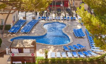 a large , blue swimming pool surrounded by lounge chairs and umbrellas in a sunny outdoor setting at Mll Palma Bay Club Resort