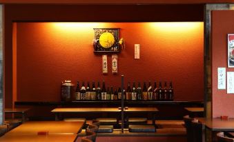 a restaurant with a long table and several bottles of alcohol on it , creating a welcoming atmosphere at Hotel Wing International Himeji