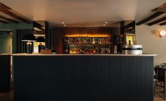a bar with a black counter and shelves filled with various bottles of liquor , creating an inviting atmosphere at The Star