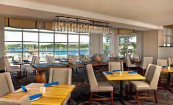 a dining room with a large window overlooking a body of water , providing a scenic view at Sheraton Portsmouth Harborside Hotel