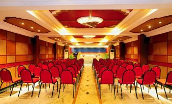 a large conference room with rows of red chairs arranged in a semicircle , ready for an event at Hotel Sea View