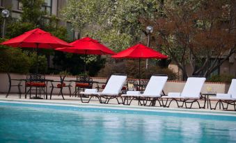 a swimming pool surrounded by lounge chairs and umbrellas , providing a relaxing atmosphere for guests at Washington Dulles Airport Marriott