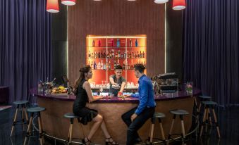 a man and a woman sitting at a bar , with the man dressed in a tuxedo at Mercure Hai Phong