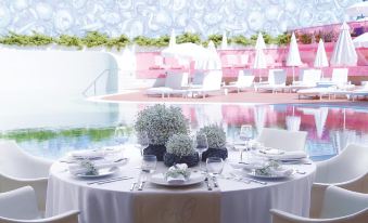 a well - decorated dining table set for a formal event , with multiple chairs surrounding it and a pool in the background at Semiramis