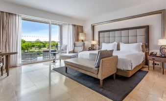 a modern hotel room with a large bed , couch , and sliding glass doors leading to an outdoor terrace at Conrad Algarve