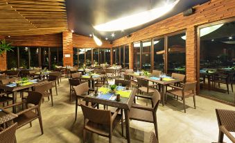 an indoor restaurant with wooden tables and chairs arranged in rows , providing seating for guests at Astoria Palawan