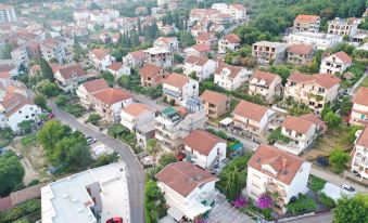 an aerial view of a residential area with houses , trees , and a white street in the foreground at D&D Apartments