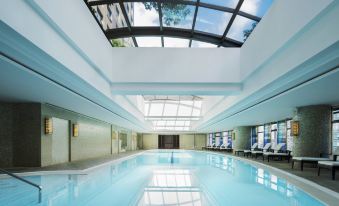 The building features an indoor pool with large windows and a blue ceiling on the right side at Swissotel Grand Shanghai