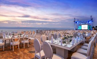 a large , elegant wedding reception with multiple tables and chairs set up for guests , overlooking the ocean at Kempinski Hotel Ishtar Dead Sea
