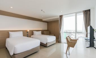 a modern hotel room with two beds , white bedding , and a large window offering a view of the city at Rattanachol Hotel