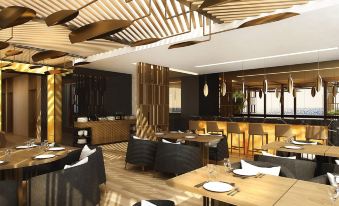 a modern restaurant with wooden tables and chairs , a bar area , and pendant lights hanging from the ceiling at Swiss-Belboutique Bneid Al Gar Kuwait