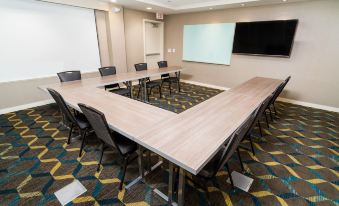 a conference room with a wooden table , chairs , and a large screen on the wall at Residence Inn Upper Marlboro Joint Base Andrews
