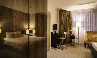 a hotel room with a bed , desk , and chair , as well as curtains and a window at The Hide London