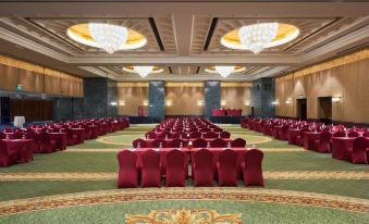 a large banquet hall with red chairs arranged in rows and a chandelier hanging from the ceiling at Grand Nile Tower