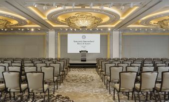 a conference room with rows of chairs arranged in front of a large screen , likely for a meeting or presentation at Kempinski Summerland Hotel & Resort Beirut