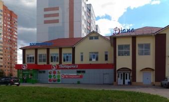 "a large building with a red roof and the sign "" diana "" is next to it" at Diana