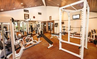 a well - equipped gym with various exercise equipment , including weights and treadmills , in a spacious room at Lorin Dwangsa Solo Hotel