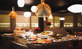 a buffet table filled with a variety of food items , including fruits , pastries , and desserts at Hotel Ambassador Zermatt