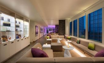 a modern living room with multiple couches and chairs arranged in various positions , creating a cozy and inviting atmosphere at Yotel Boston