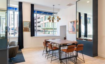 a modern office space with a wooden table , chairs , and large windows overlooking a cityscape at Hilton Garden Inn Flint Downtown