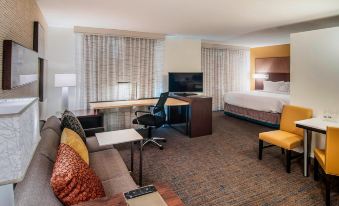 a modern hotel room with a living area , dining table , and a tv , as well as a bed , couch , and other furniture at Residence Inn Rapid City